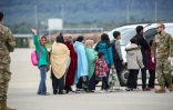 Des réfugiés afghans s'apprêtant à monter dans l'avion les évacuant vers les Etats-Unis, après quelques jours passés sur la base aérienne américaine de Ramstein, en Allemagne, le 26 août 2021