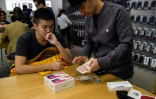 Un homme achète deux iPhone X dans une boutique Apple, le 3 novembre 2017 à Hong Kong