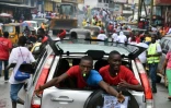 Des partisans du candidat à la présidentiel Alexander Cummings à bord d'un véhicule dans une rue de Monrovia, le 7 octobre 2017 au Liberia