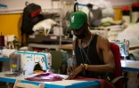 Un migrant africain travaille dans l'atelier de la marque Top Manta créée par le syndicat des vendeurs à la sauvette, le 11 juin 2021 à Barcelone