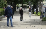 Un homme portant un masque de protection joue à la pétanque au deuxième jour de l'assouplissement des mesures de confinement adoptées pour lutter contre le coronavirus, le 12 mai 2020 à Paris