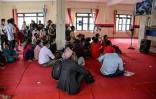 Des familles regardent un écran affichant les identités des victimes de la crue destructrice dans l'Himalaya, le 30 août 2026 Bharatpur, à l'ouest de Katmandou
