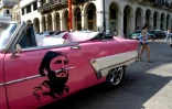 Un portrait de Fidel Castro jeune sur la portière d'une vieille voiture américaine dans une rue de La Havane, le 24 novembre 2017 à Cuba