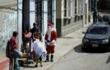 Un homme déguisé en Père Noël lors de l'opération "Santa en las calles" (le Père Noël dans la rue), le 16 décembre 2017 à Caracas, au Venezuela