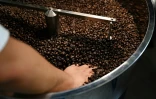 Liao Shihao vérifie les grains de café après leur torréfaction à la plantation Xiaowazi à Pu'er, le 1er avril 2025 dans la province du Yunnan, dans le sud-ouest de la Chine