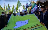 Des manifestants kurdes agitent le drapeau à trois étoiles de l'indépendance syrienne, le 19 décembre 2024 à Qamichli, dans le nord de la Turquie