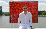 L'artiste chinois Liu Bolin prend la pose devant l'une de ses oeuvres lors d'une exposition à Vichy le 16 juin 2017