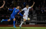 Le défenseur de l'équipe de France Lucas Digne (d) à la lutte avec le milieu de l'Islande Emil Hallfredsson en qualif de l'Euro-2020, le 11 octobre 2019 à Reykjavik