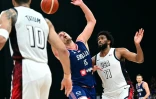 Le pivot serbe Nikola Jokic entre l'ailier Jayson Tatum (gauche) et l'intérieur Joel Embiid (droite) de l'équipe américaine, le 17 juillet 2024 à l'Etihad Arena d'Abu Dhabi, aux Emirats arabes unis