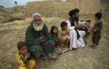 Des hommes et des enfants assis près d'une maison à Kajaki, dans la province du Helmand, le 22 mars 2021 en Afghanistan