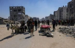 Des Palestiniens se tiennent autour d’un âne tué lors d’une frappe de drone israélien à Jabalia, dans le nord de la bande de Gaza, le 23 mai 2025