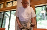 Le prêtre bouddhiste Eiichi Shinohara regarde le journal d'une femme qui s'est fait escroquer des millions de yens, lors d'une interview avec l'AFP dans son temple à Narita, à l'est de Tokyo, le 5 septembre 2023