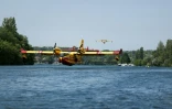 Un Canadair CL-415 de la Sécurité civile effectue des manœuvres d'écopage au-dessus de la Seine à Chartrettes, pour lutter contre un incendie dans la forêt de Fontainebleau, en Ile-de-France