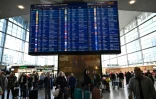 Des voyageurs consultent un panneau d'information sur les vols à l'aéroport de Copenhague, après un survol de drones, le 23 septembre 2025 au Danemark