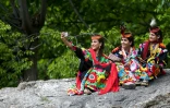 Des femmes de la minorité kalash, en costume traditionnel, font un selfie lors du festival du printemps, le 16 mai 2019 à Bumburate, au Pakistan