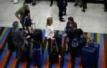 Des passagers font la queue aux comptoirs d'enregistrement d'American Airlines avant l'arrivée d'un vol en provenance de Miami, en Floride, à l'aéroport international Simon Bolivar de La Guaira, dans l'État de La Guaira, au Venezuela, le 30 avril 2026