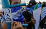 Un étudiant brandit une pancarte sur laquelle est dessiné le président du Nicaragua Daniel Ortega avec écrit, au-dessous "assassin recherché", à Managua le 15 mai 2018