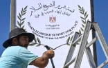 Un employé municipal installe un panneau à Charm el-Cheikh, dans l'est de l'Egypte, qui se prépare à accueillir un "sommet pour la paix" à Gaza parrainé par les Etats-Unis, le 12 octobre 2025
