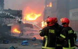Des pompiers luttent contre un incendie dans un entrepôt de conteneurs, le 5 juin 2022 à Sitakunda, au Bangladesh