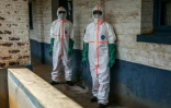Des agents de santé en combinaison de protection désinfectent la zone d'isolement des patients atteints d'Ebola à l'hôpital de Mongbwalu, le 23 mai 2026 en RDC