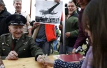 L'ancien pilote de l'armée de l'air américaine Gail Halvorsen reçoit des fleurs offertes par une fillette, lors d'une cérémonie de commémoration du 70e anniversaire du pont aérien de Berlin, le 11 mai 2019 à Berlin