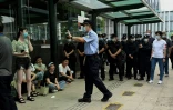 Propriétaires spoliés et policiers se font face devant le siège d'Evergrande, à Shenzhen, le 15 septembre 2021, au troisième jour de ressemblement contre le géant immobilier chinois