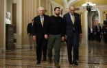 Le président ukrainien Volodymyr Zelensky au Capitole, siège du Congrès américain, en compagnie du leader de la majorité démocrate au Sénat Chuck Schumer (dr) et du chef de file des sénateurs républicains, Mitch McConnell (g), le 12 décembre 2023