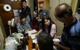 Sze Lai-shan (2e d), directrice adjointe de la SOCO, une ONG travaillant avec des groupes défavorisés, parle avec des habitants de logement subdivisés, le 4 mai 2026 à Hong Kong
