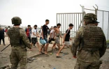 Soldiers watching as migrants cross back into Morocco