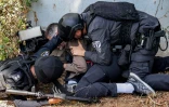 Des policiers israéliens et un journaliste se mettent à l'abri pendant une alerte à la roquette à Sdérot, en Israël, le 12 octobre 2023