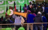Un soutien de la coalition Azimio la Umoja de Raila Odinga soulève le pupitre de la commission électorale (IEBC) le 15 août 2022 à Nairobi (Kenya)