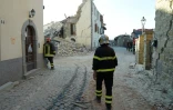 Des pompiers inspectent les bâtiments du village d'Amatrice le 27 août 2016