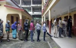 Les électeurs font la queue devant un bureau de vote dans une école de Conakry, le 21 septembre 2025, alors que la Guinée vote lors d'un référendum constitutionnel.