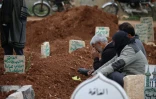 Des Syriens sur la tombe de leurs proches le 29 mars 2016 à Daraa