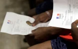 Des réfugiés du Lifeline tiennent entre leur main le "Laissez-Passer Europeen", le 5 juilllet 2018 à Roissy
