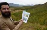 Pervaiz Manan, responsable forestier, montre des photos de la zone avant le programme de reboisement, le 17 mai 2018 à Heroshah, dans la vallée du Swat, au Pakistan