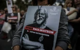 Une femme tient une pancarte avec l'inscription "#LibérezPaulWatson - Pas d'extradition vers le Japon" écrite sur une photo de Paul Watson, fondateur de l'ONG Sea Shepherd, lors d'une manifestation de soutien à Paris le 4 septembre 2024