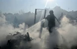 Un pompier éteint un incendie dans des maisons après une attaque russe meurtrière sur Kharkiv le 11 octobre 2026