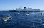 Des pêcheurs philippains devant un navire militaire chinois au large du récif de Scraborough, un îlot contrôlé par la Chine mais revendiqué par les Philippines, le 15 février 2024
