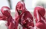 Des migrants attendent après avoir débarqué d'un navire après leur sauvetage en mer alors que leur embarcation avait pris feu lors d'une tentative de traversée de la Manche, au port de commerce de Boulogne-sur-Mer, le 4 août 2026