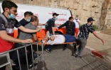 Des secouristes palestiniens évacuent un blessé lors de heurts avec la police israélienne à Jérusalem, le 10 mai 2021