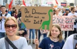 Une manifestante tient un panneau "Les dinosaures pensaient aussi avoir le temps" lors d'un rassemblement Ă Vienne le 27 septembre 2019