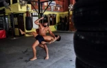 Deux boxeurs professionnels, Pongpisarn Sunyong (en haut) et Sarawut Prohmsut, à l'entraînement avec un masque dans une salle de muay thaï de Bangkok le 9 avril 2020