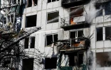 Les pompiers tentent d'éteindre un incendie dans un immeuble après un bombardement à Tchouhouïv (Ukraine) le 24 février 2022