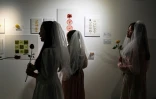 Des jeunes filles costumées en mariées pour célébrer symboliquement l'acceptation de leur corps visitent une exposition anti-"body shaming" au musée Himalaya de Shanghai, le 14 mai 2021