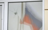 Un drapeau russe reflété dans une vitre endommagée par une attaque aérienne à Razumnoye (Russie), près de Belgorod, le 19 mars 2024