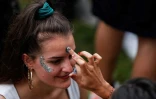 Une femme se fait maquiller pendant la Fête de la musique au parc Villemin, près du Canal Saint-Martin à Paris, le 21 juin 2020