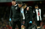 Le défenseur irlandais de Newcastle, Ciaran Clark (c), blessé, quitte la pelouse soutenu par son équipe médicale lors du match de Premier League face à Arsenal, à Londres, le 16 février 2020