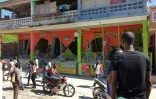 Des passants près d'une maison effrondrée dans une rue de la ville de Jérémie, près de l'épicentre du séisme au sud-ouest de la péninsule d'Haïti, le 14 août 2021 