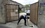 Un gendarme ramasse des fleurs à l'entrée de la communauté religieuse à Saint-Laurent-sur-Sevres, le 9 août 2021